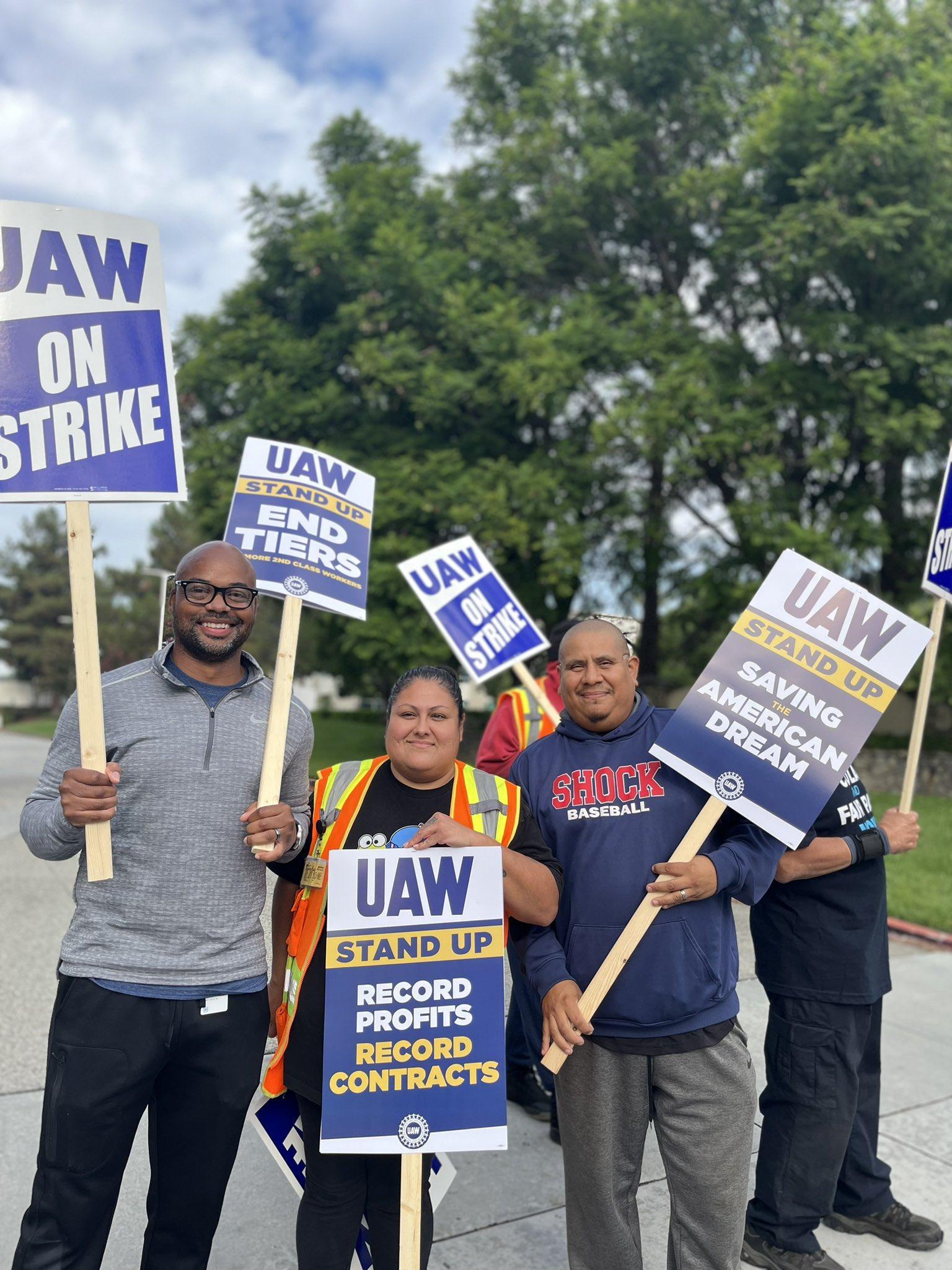 Three UAW 6645 members holding picket signs