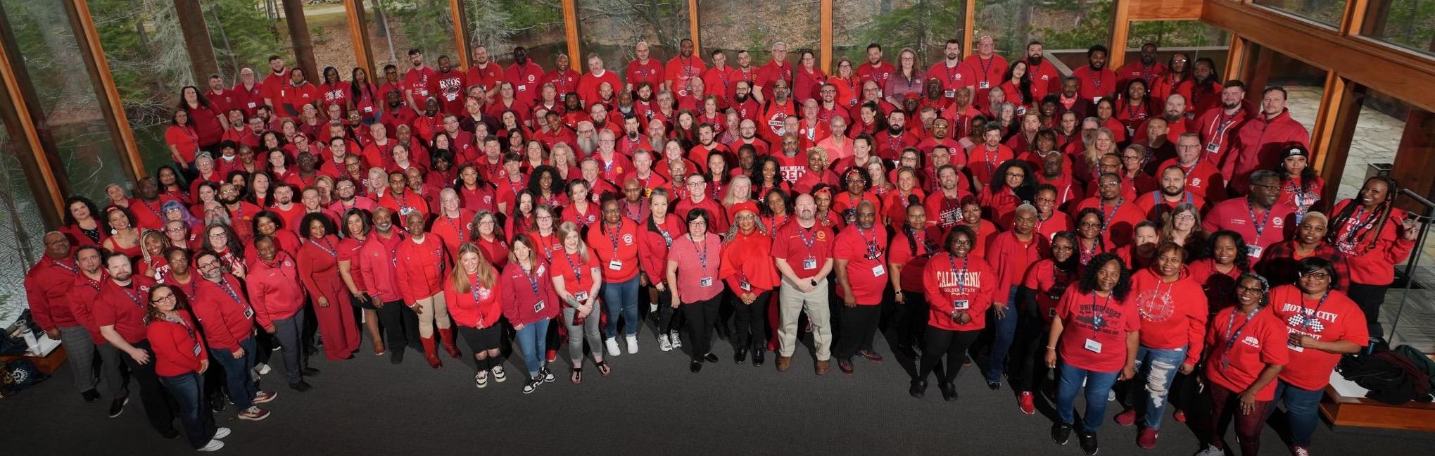 Hundreds of UAW members in red shirts posed for a photo in the Walter & May Reuther Family Education Center