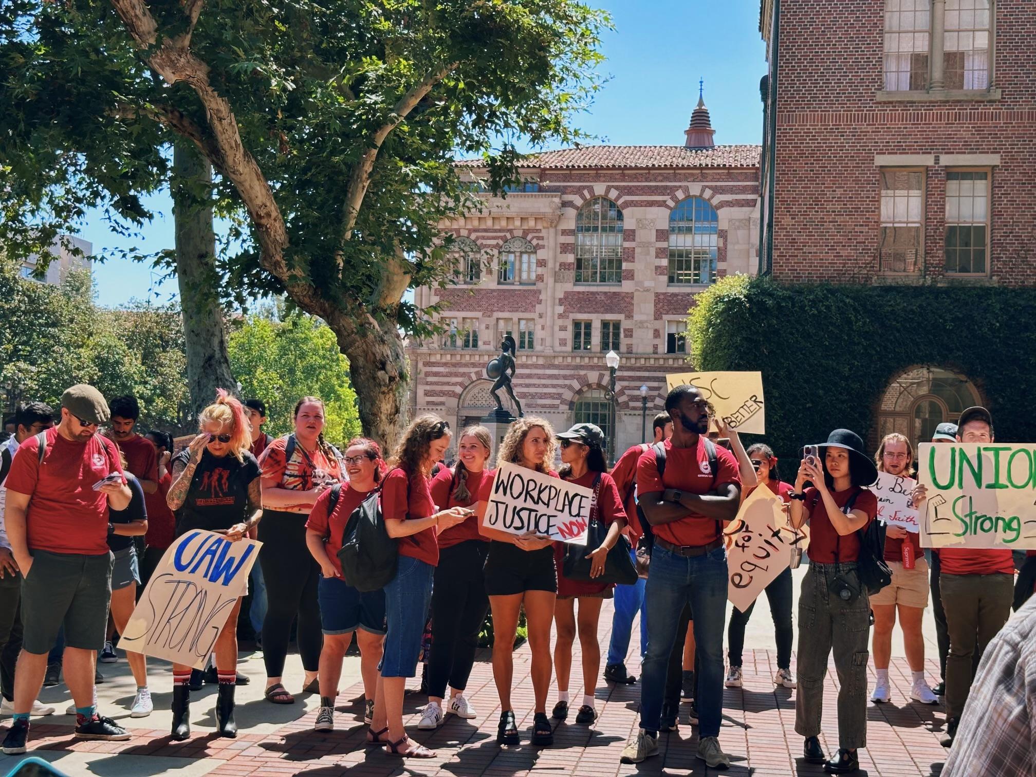 A large group of USC Grad Workers standing at a rally, many holding signs